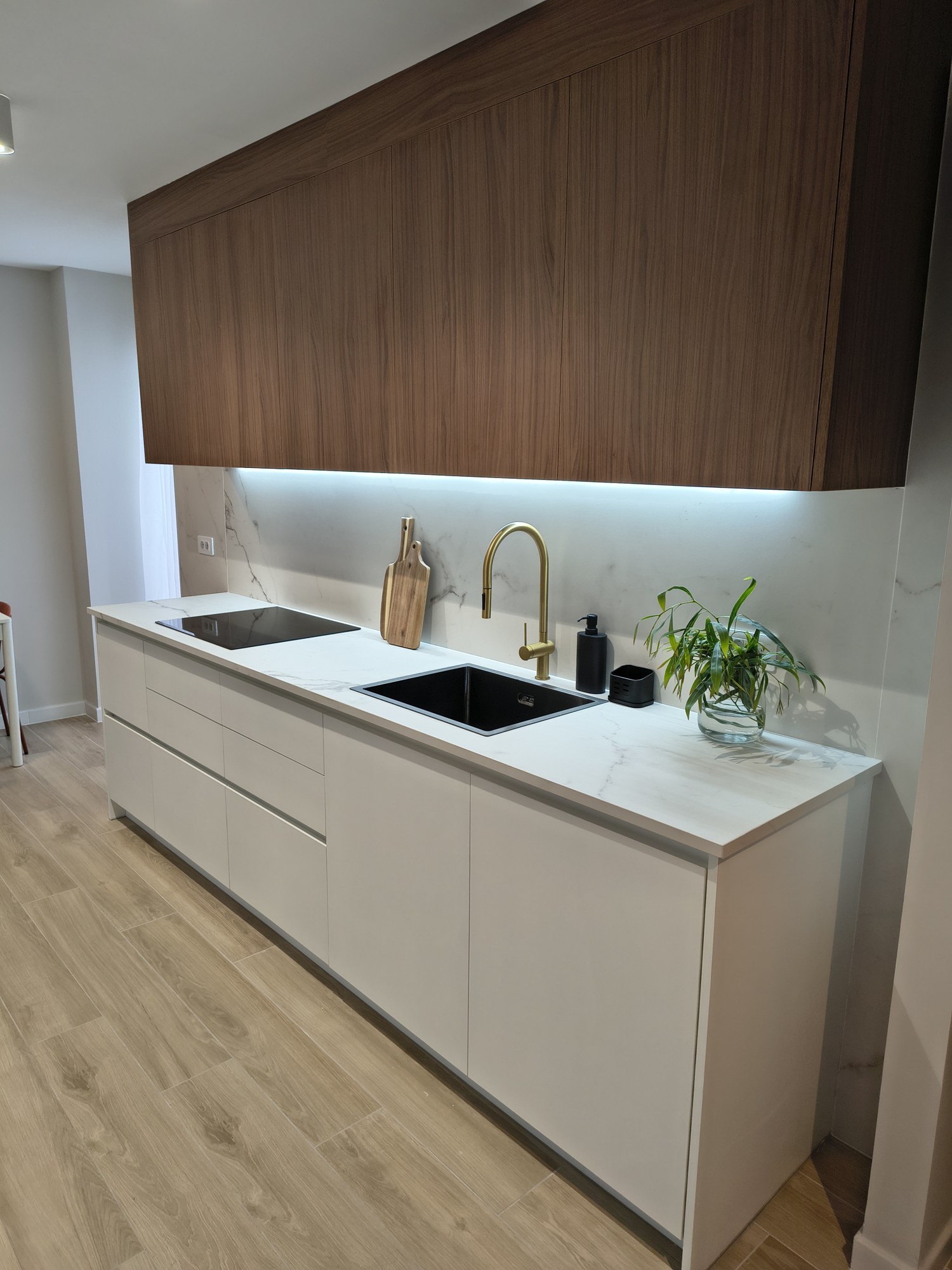 Detalle de muebles altos en nogal con iluminación lineal
