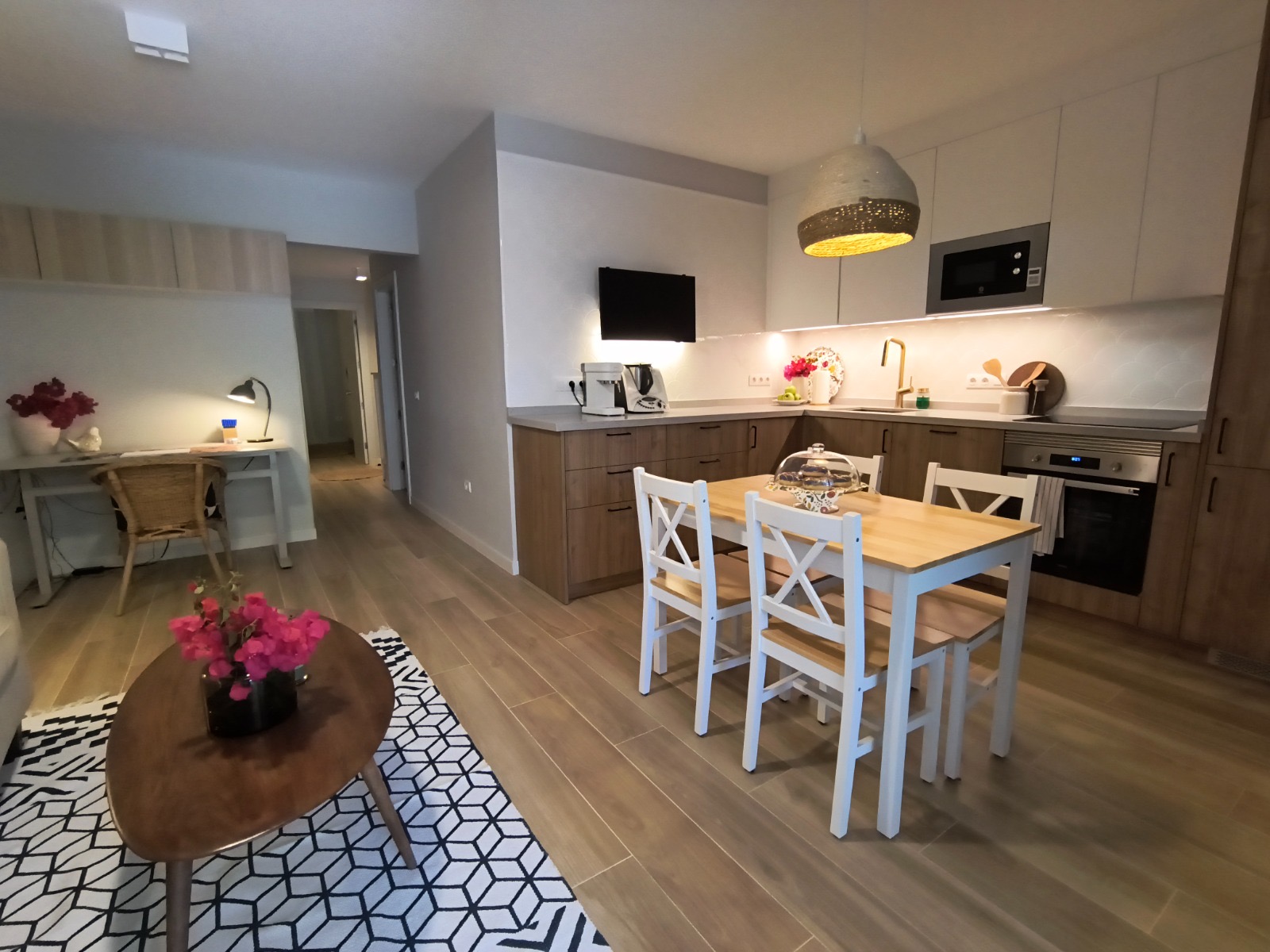 Cocina en L con isla de comedor e iluminación cálida