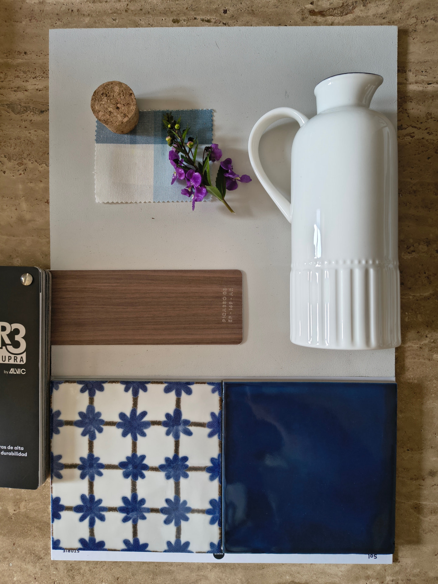 Moodboard con muestras de tela, pintura y materiales en tonos azules y neutros